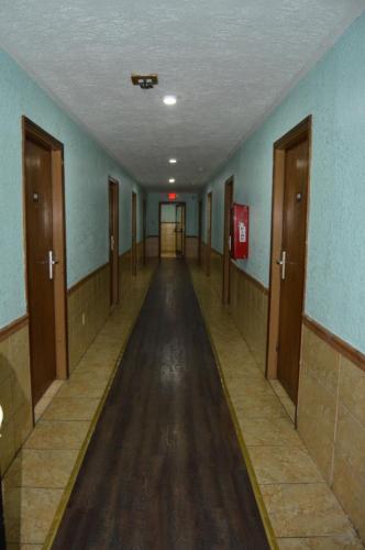 an empty hallway with blue walls and wooden doors at Budget Inn Richlands Claypool Hill in Tazewell