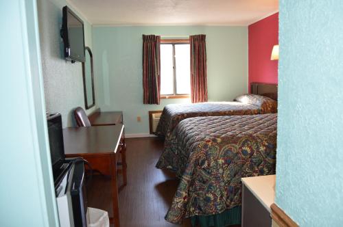 a hotel room with two beds and a window at Budget Inn Richlands Claypool Hill in Tazewell