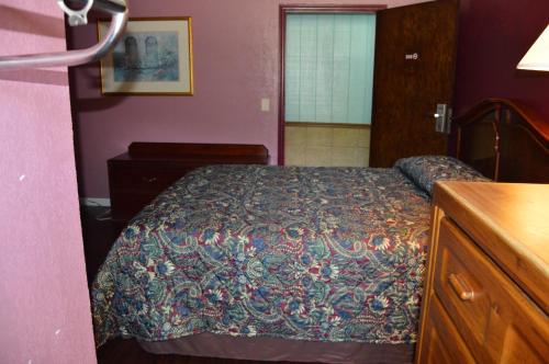 a bedroom with a bed and a dresser and a bed sidx sidx sidx sidx at Budget Inn Richlands Claypool Hill in Tazewell