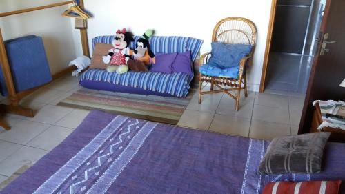 a living room with a couch with stuffed animals on it at Refúgio do Azzi in Monte Verde