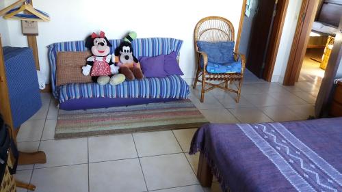 two stuffed animals sitting on a couch in a room at Refúgio do Azzi in Monte Verde