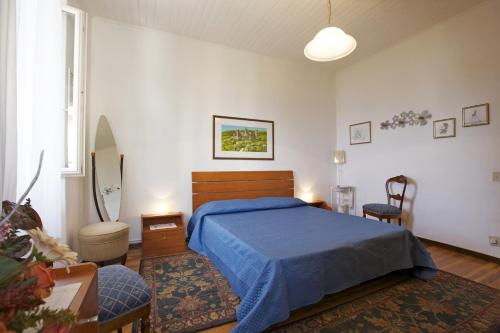 a bedroom with a bed with a blue bedspread at Piazzale Italia in Oggebbio