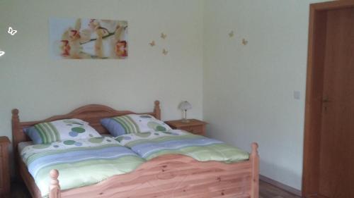 - une chambre avec un lit doté d'une tête de lit en bois dans l'établissement Ferienwohnung Bergblick, à Kleingießhübel
