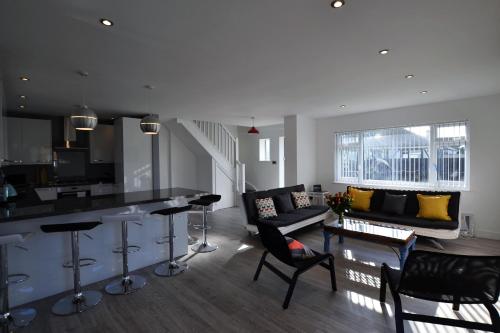a kitchen and living room with a bar and a couch at South Coast Haven Apartments in Peacehaven