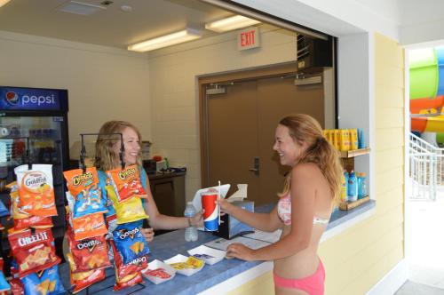 two girls are standing at a counter in a store at Country Cascades Waterpark Resort in Pigeon Forge