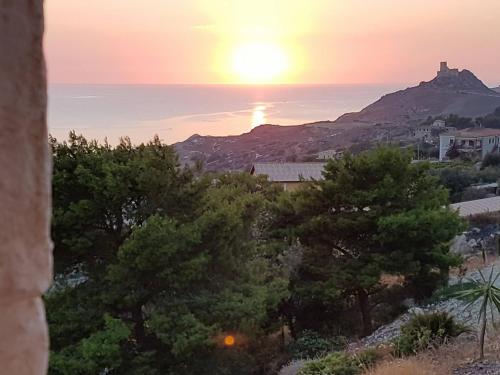 a sunset over the ocean from a hill with trees at B&B Terrazze Chiaramontane in Marina di Palma