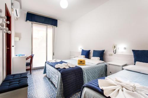 a bedroom with two beds and a window at Hotel San Pietro in Cervia