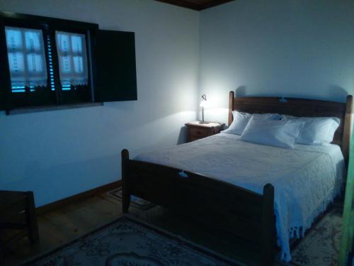 een slaapkamer met een bed, een raam en een lamp bij Casa Do Grilo Soajo in Soajo