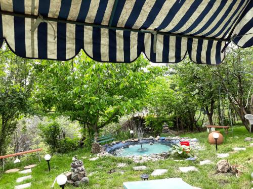 een parasol op de patio boven een zwembad in een tuin bij SUNNY SWEET HOME in Dilidzjan