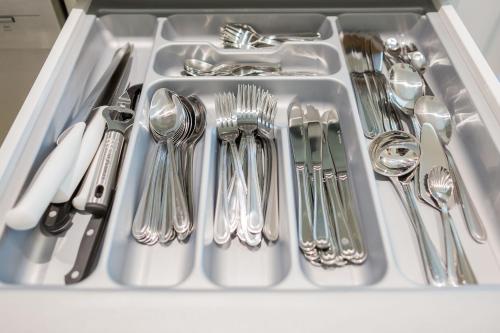 a sink with silver utensils in it at Salzburg City Appartement in Salzburg