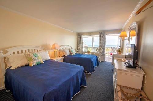 a hotel room with two beds and a television at Adams Ocean Front Resort in Dewey Beach