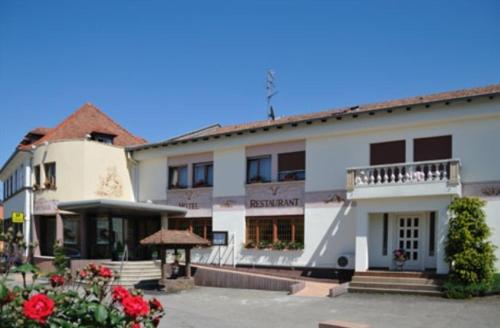 a large white building with a balcony and flowers at Logis Hotel Restaurant Au Boeuf Rouge in Niederschaeffolsheim