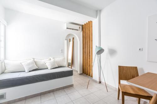 Sala de estar con cama y mesa en Fanouris Condo - Adults Only, en Kamari