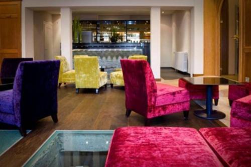 a lobby with chairs and a table and a bar at Logis Hotel Restaurant Au Boeuf Rouge in Niederschaeffolsheim