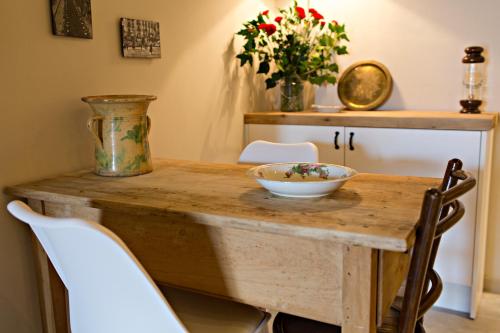 a wooden table with two chairs and a bowl on it at El Jardinet de Sant Esteve in Olot