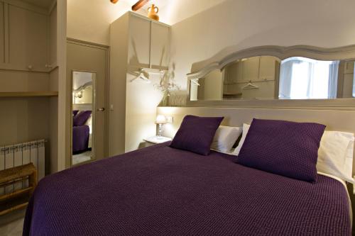 a bedroom with a purple bed and a mirror at El Jardinet de Sant Esteve in Olot