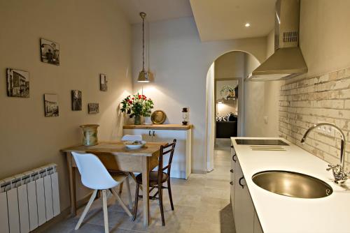 a kitchen with a sink and a table with chairs at El Jardinet de Sant Esteve in Olot