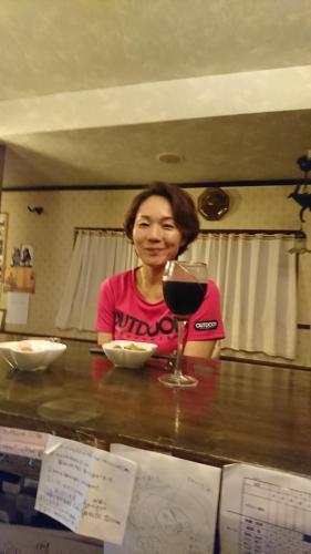 a woman sitting at a counter with a glass of wine at Live Cafe Hisui no Umi in Itoigawa