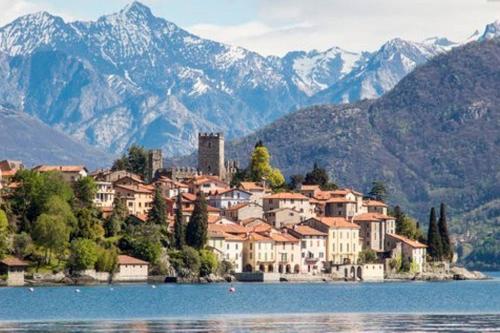 a town on the shore of a lake with mountains at Il Nido in Rezzonico