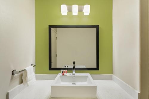 a bathroom with a white sink and a mirror at Baymont by Wyndham Modesto Salida in Modesto