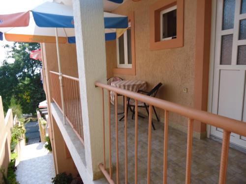 a balcony of a house with an umbrella at Apartments Villa Mićunović in Herceg-Novi