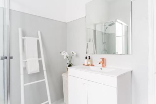a white bathroom with a sink and a mirror at City Lofts Lisbon - Guesthouse in Lisbon