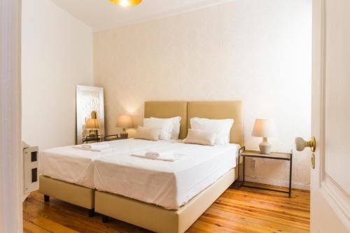 a bedroom with a large bed with white sheets at City Lofts Lisbon - Guesthouse in Lisbon