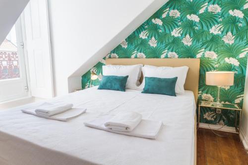 a bedroom with a large bed with two towels on it at City Lofts Lisbon - Guesthouse in Lisbon