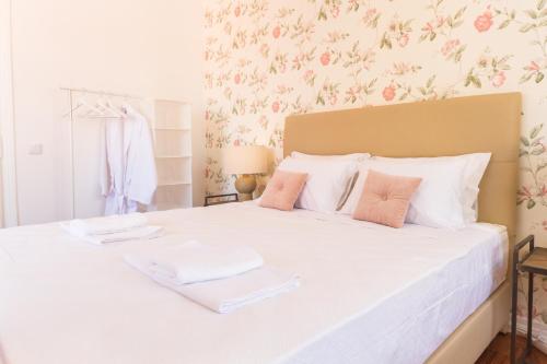 a bedroom with a white bed with two towels on it at City Lofts Lisbon - Guesthouse in Lisbon