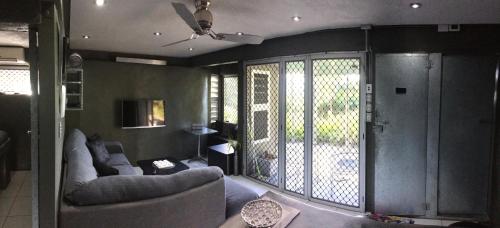 a living room with two couches and a balcony at Earthship Daintree in Cow Bay