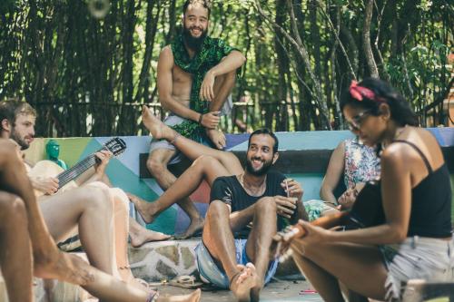 a group of people sitting around a pool playing music at Lagarto Na Banana Hostel in Pipa