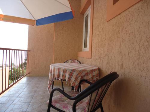a table and two chairs on a balcony at Apartments Villa Mićunović in Herceg-Novi
