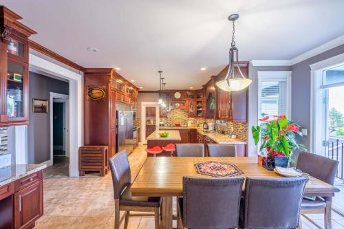 a kitchen and dining room with a wooden table and chairs at Vancouver Yuelai Guesthouse in Coquitlam