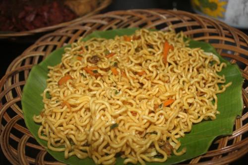 a plate of noodles on a green plate at Rabbani Family Homestay in Yogyakarta