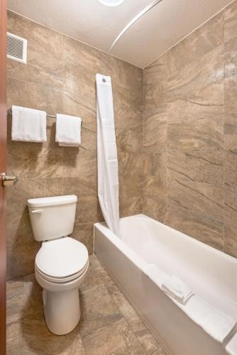 a bathroom with a toilet and a bath tub at Ellis Island Hotel Casino & Brewery in Las Vegas