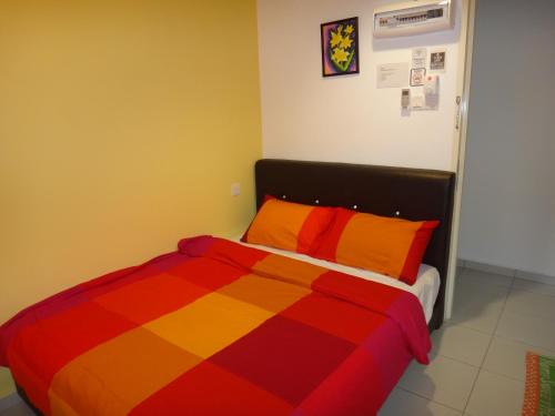 a bed with a colorful striped comforter in a room at Famosa 2 Stay in Melaka