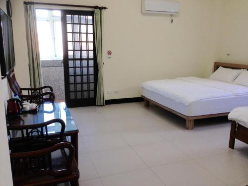 北竿鄉的住宿－羅馬佳洲民宿 ，一间卧室配有一张床、一张桌子和一个窗户。