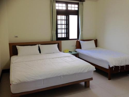 北竿鄉的住宿－羅馬佳洲民宿 ，一间卧室设有两张床和窗户。
