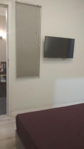 a flat screen tv hanging on a white wall at SleepRest - Plamo Garden in Batam Center