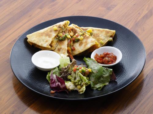 a black plate with tacos and salad on a table at IZE Seminyak by LifestyleRetreats in Seminyak