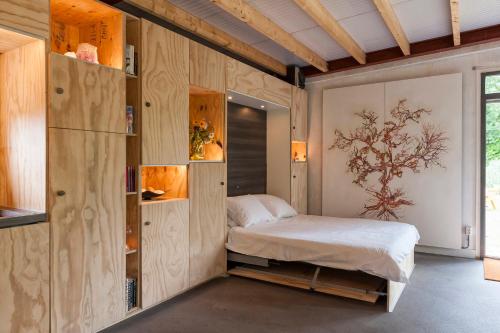 a bedroom with a bed and wooden walls at Stijlvol Atelier in het groen in Liempde