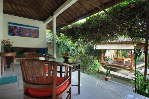 a dining room with a table and chairs on a patio at Nara Ubud Cottage by Mahaputra in Ubud