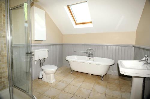y baño con bañera, aseo y lavamanos. en Homeplace Retreat Bellaghy Top Rated Property for Families Min 2 nights, en Bellaghy