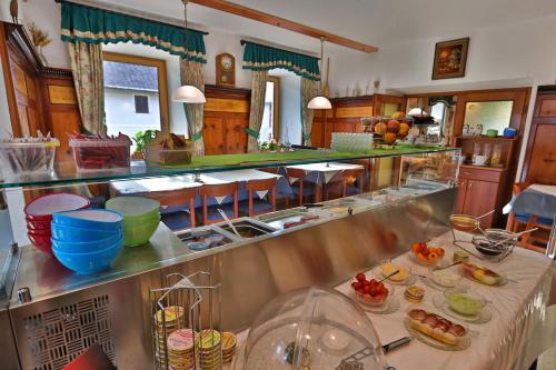 a restaurant with a buffet line with food on it at Hotel Beim Winkler in Tröpolach