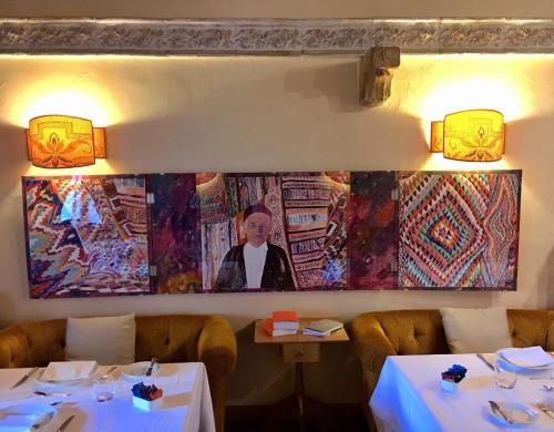 a painting of a man on the wall of a restaurant at Locanda Caino in Montemerano