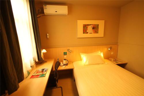 a room with two beds and a desk and a window at Jinjiang Inn Changzhi Bayi Square in Changzhi