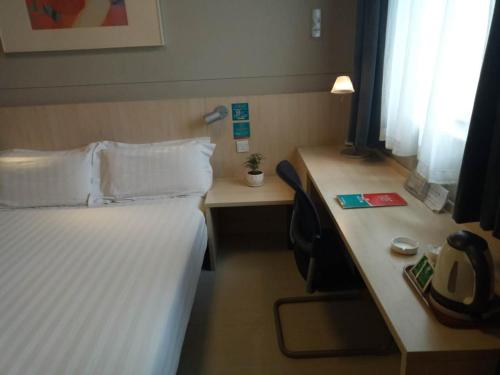 a hotel room with a bed and a desk at Jinjiang Inn Changzhi Bayi Square in Changzhi