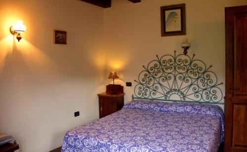 1 dormitorio con 1 cama con edredón morado en Le Petit Chateau, en Vezzi Portio