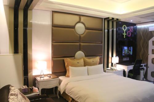 a bedroom with a large white bed and two lamps at Kai-Hong Motel in Longtan