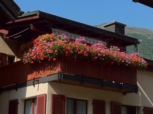 a balcony with flowers on the side of a building at Privatzimmer / bed & breakfast in Andermatt